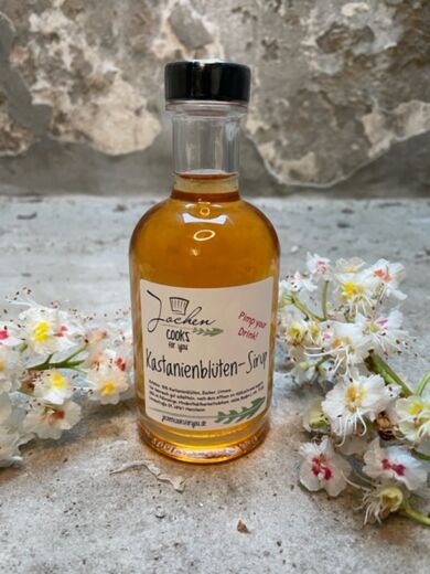 Kastanienblüten Sirup in der Flasche mit Schraubverschluss und Blüten als Deko.