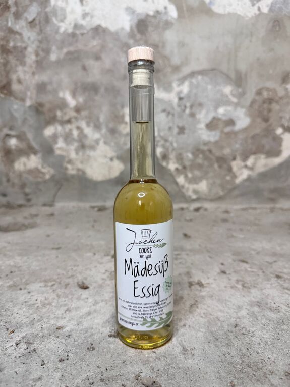 Mädesüß Essig in der Flasche mit Korkverschluss und Blüsen als Deko.